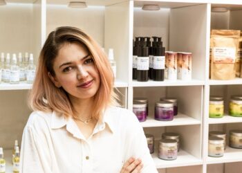 Twórczyni marki Auna Vegan na tle swoich kosmetyków marki Auna Vegan